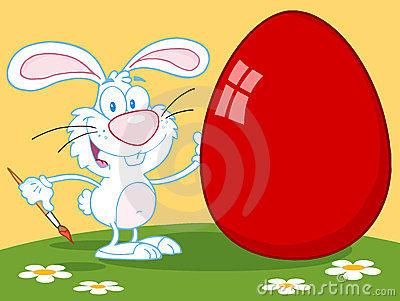 happy rabbit painting red easter egg outdoors 23896608